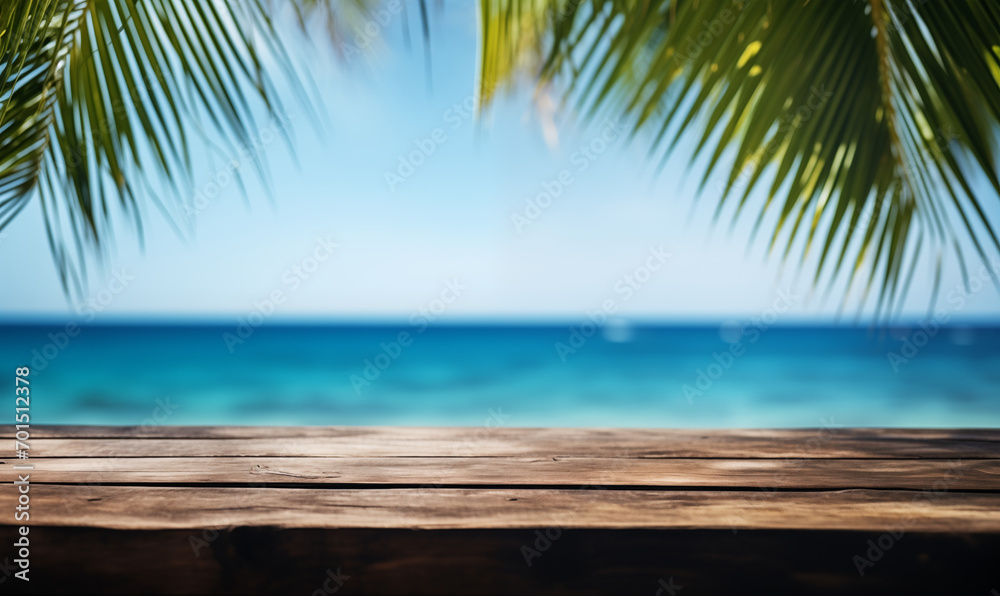 A wooden table on an exotic beach, palm leaves on a blurry background, with the blue ocean in the background. Holiday atmosphere