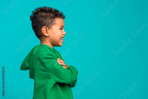 Profile side photo of adorable cute boy dressed trendy green clothes looking empty space isolated on cyan color background