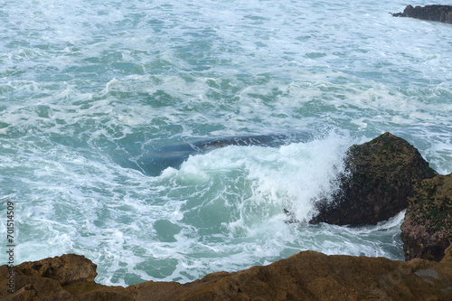View from above waves breaking on headland and making whirlpool. Copy advertising space. Atlantic ocean. Nature backdrop