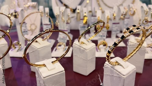 Women's gold bracelets in a jewelry store window. Close-up photo