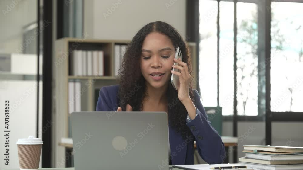 African American university woman working on a project, using a laptop and taking notes, looking focused and engaged. African American university woman working on a project, using a laptop and taking notes, looking focused and engaged.