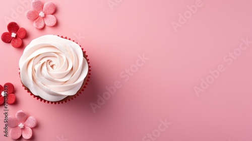  a cupcake with white frosting and pink icing on a pink background surrounded by pink and red flowers.