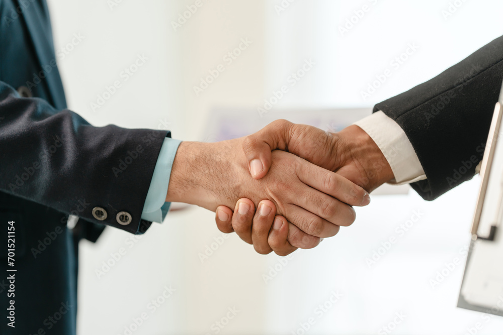 close-up of two men in business suits shaking hands, likely concluding a discussion or agreement, possibly in fields such as stock market investment, law, or real estate. close-up of two men in business suits shaking hands, likely concluding a discussion or agreement, possibly in fields such as stock market investment, law, or real estate.
