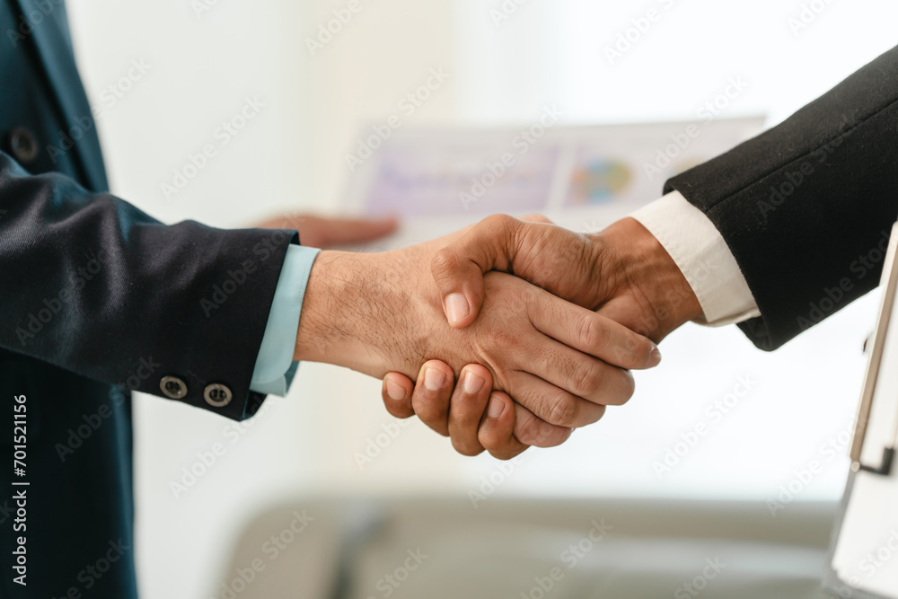 close-up of two men in business suits shaking hands, likely concluding a discussion or agreement, possibly in fields such as stock market investment, law, or real estate.