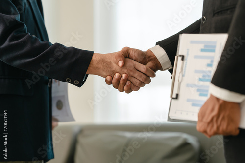 close-up of two men in business suits shaking hands, likely concluding a discussion or agreement, possibly in fields such as stock market investment, law, or real estate. photo