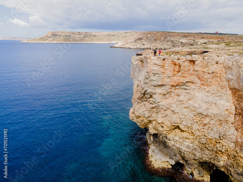 Malta. View from above. Tourists walks along a cliff.