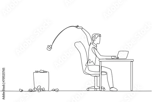 Single one line drawing businessman typing at a work desk throwing wads of paper into the trash. Does not have a clear idea of business progress. Stagnant. Continuous line design graphic illustration
