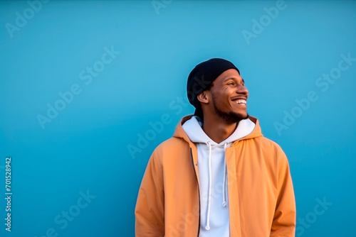 happy Moroccan man with typical moroccan tunic standing against blue wall. High quality photo