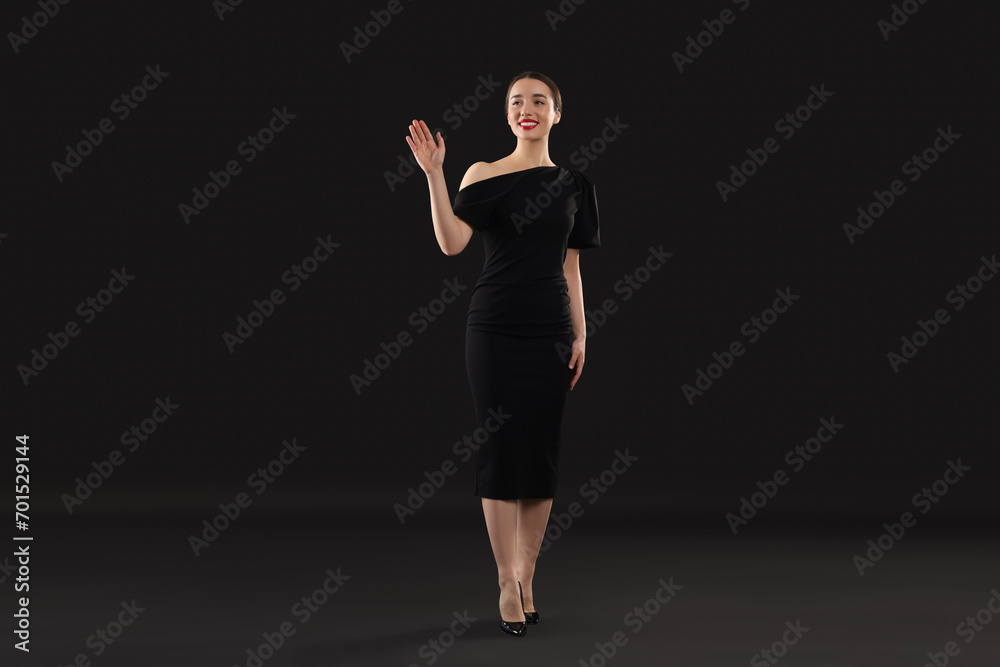 Beautiful young woman in elegant dress on black background Beautiful young woman in elegant dress on black background