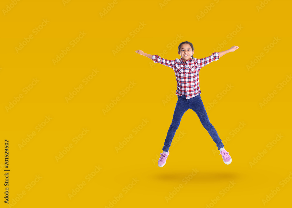 Cute girl jumping on golden background, space for text