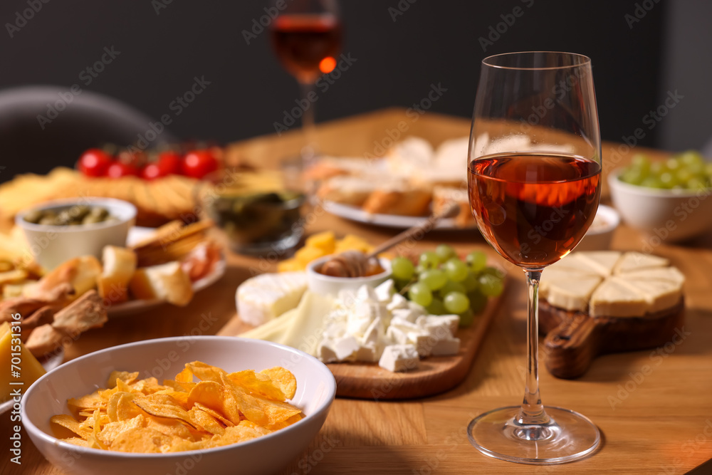 Naklejka premium Rose wine and appetizers served on wooden table, space for text