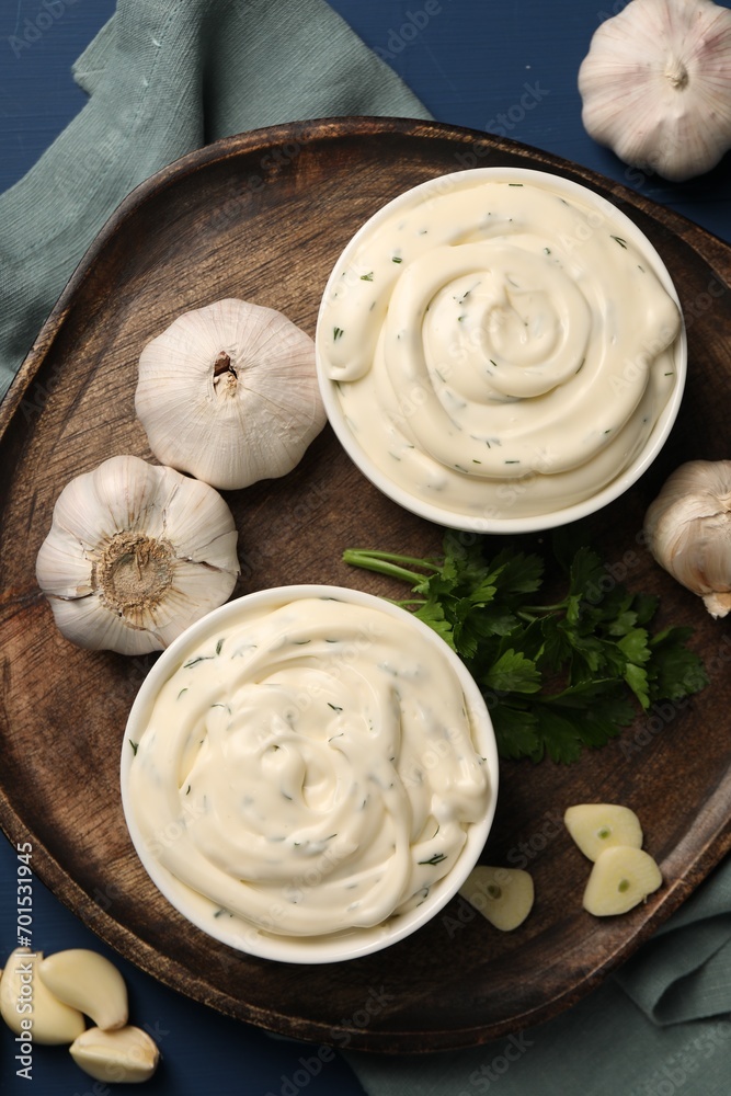 Tasty sauce with garlic and parsley on blue wooden table, flat lay