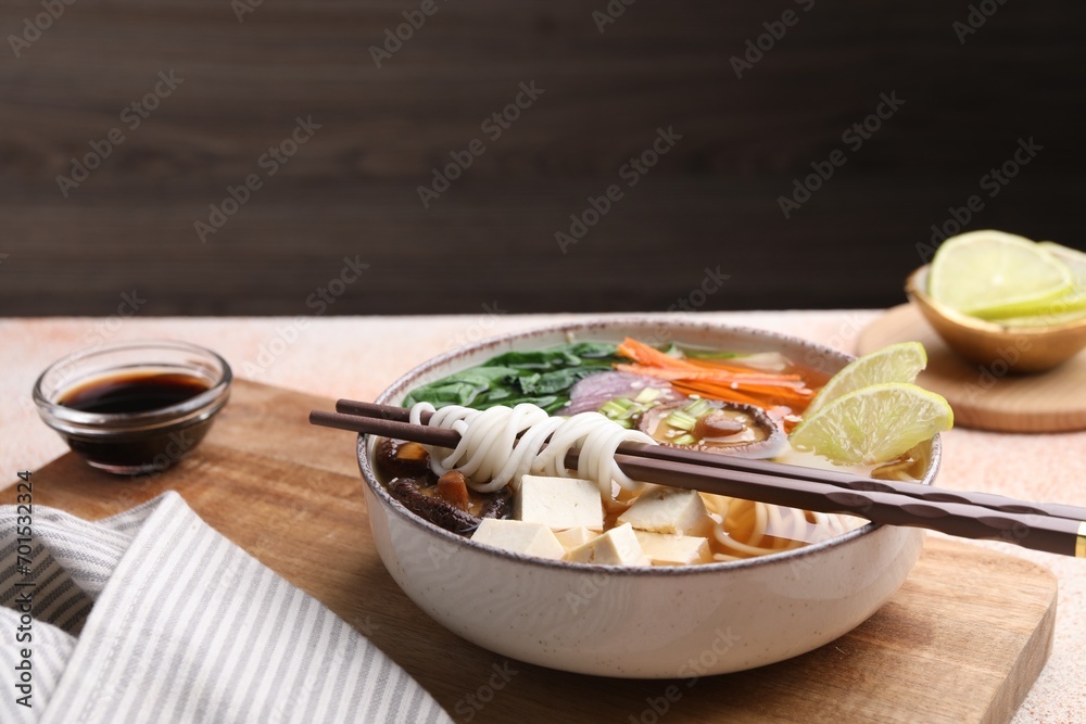Bowl of vegetarian ramen and chopsticks on light table, space for text Bowl of vegetarian ramen and chopsticks on light table, space for text