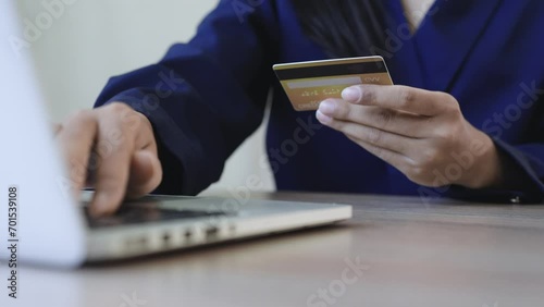 Woman hold credit card and typing information on laptop. payment online concept photo