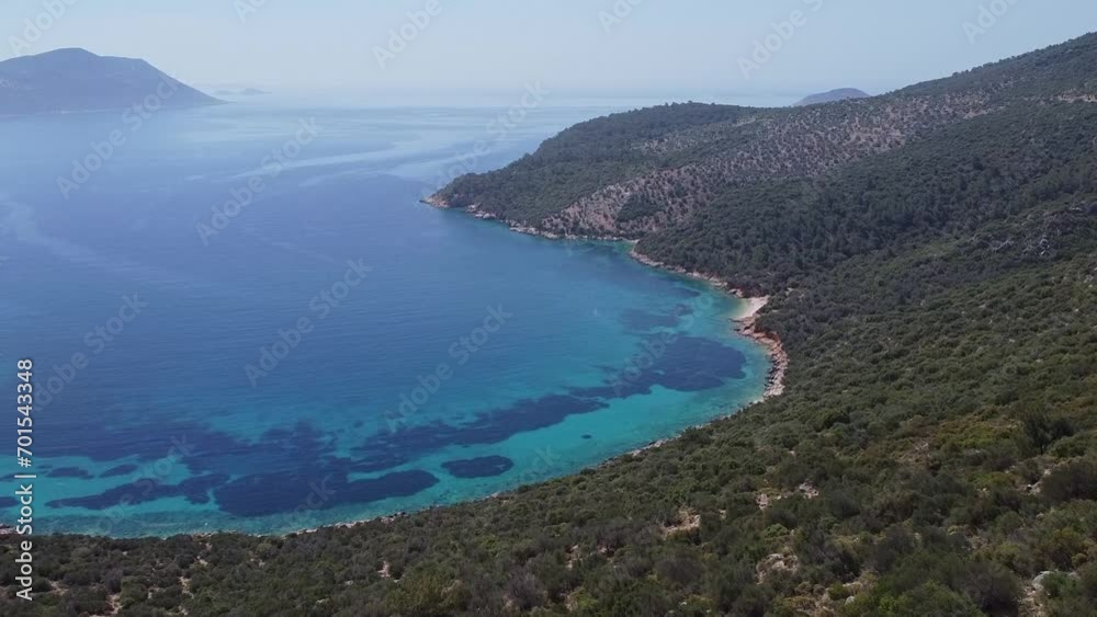 Aerial view of paradise beach of Firnaz Koyu with blue waters of Mediterranean Sea and mountains, Turkey