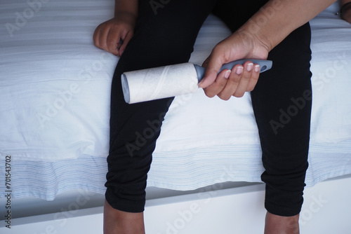 using an adhesive roller to remove lint and fluff from a bed .
