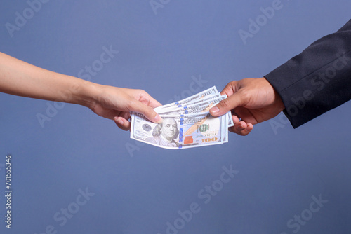 Man's hand giving bribe money to another man's hand in a corruption scam