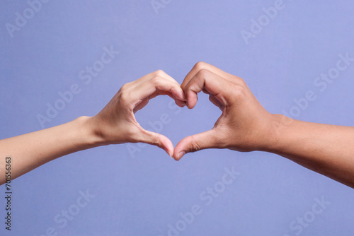 Male and female hands forming a heart shape isolated on gray background © Gatot