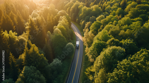 Aerial view of Overtaking trucks on an asphalt road in green forrest at sunset, Transportation concept, Generative ai. photo
