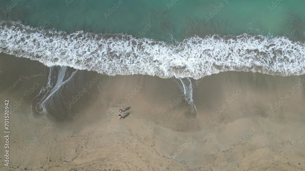 couple walk on beach with waves crashing (tropical island vacation travel destination, Luquillo Puerto Rico) caribbean sea and atlantic ocean waterfront 