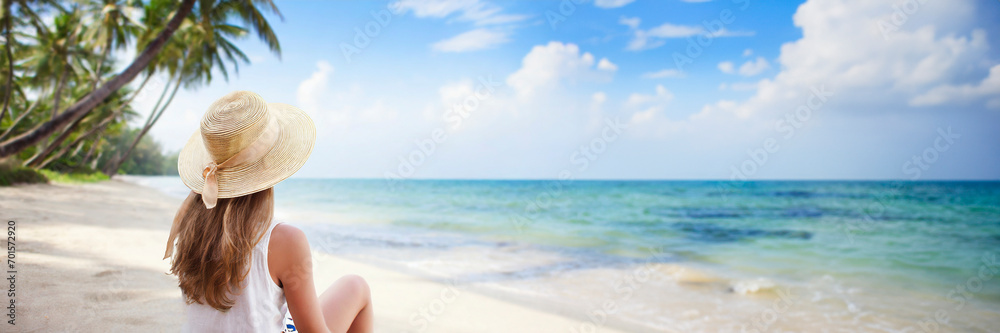 Young woman in dress and hat on sunny tropical beach. panoramic banner with copy space