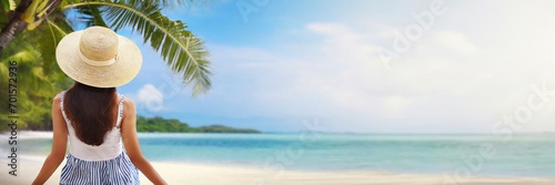Young woman in dress and hat on sunny tropical beach. panoramic banner with copy space © Mariusz Blach