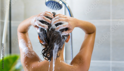 Woman washing his hair in the shower, close-up, rear view