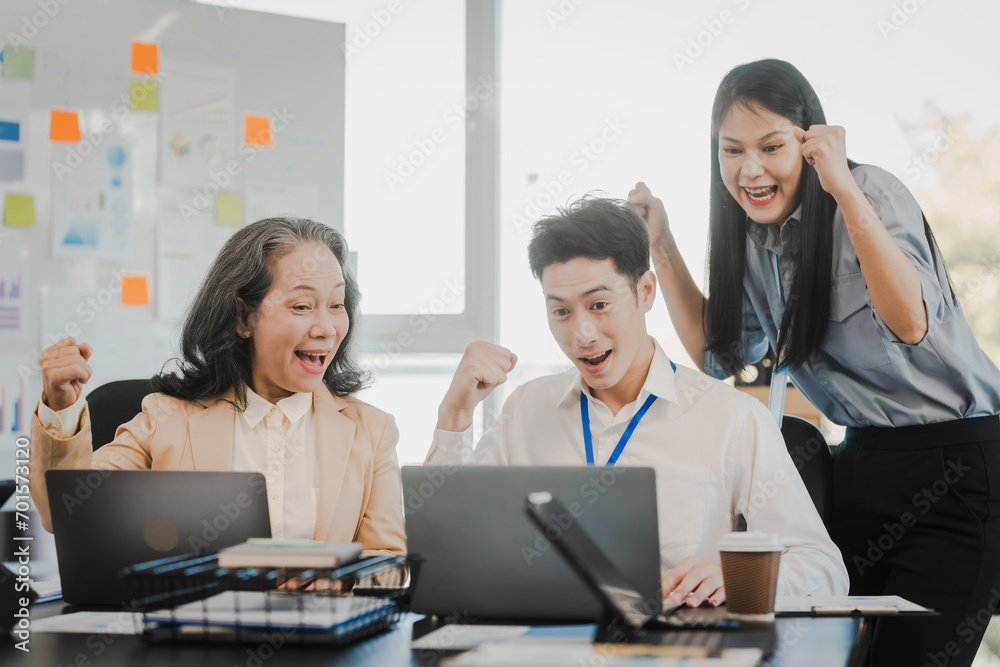 Asian office worker discussing with younger colleagues over laptops in a meeting room, possibly reviewing monthly reports or sharing opinions. Asian office worker discussing with younger colleagues over laptops in a meeting room, possibly reviewing monthly reports or sharing opinions.