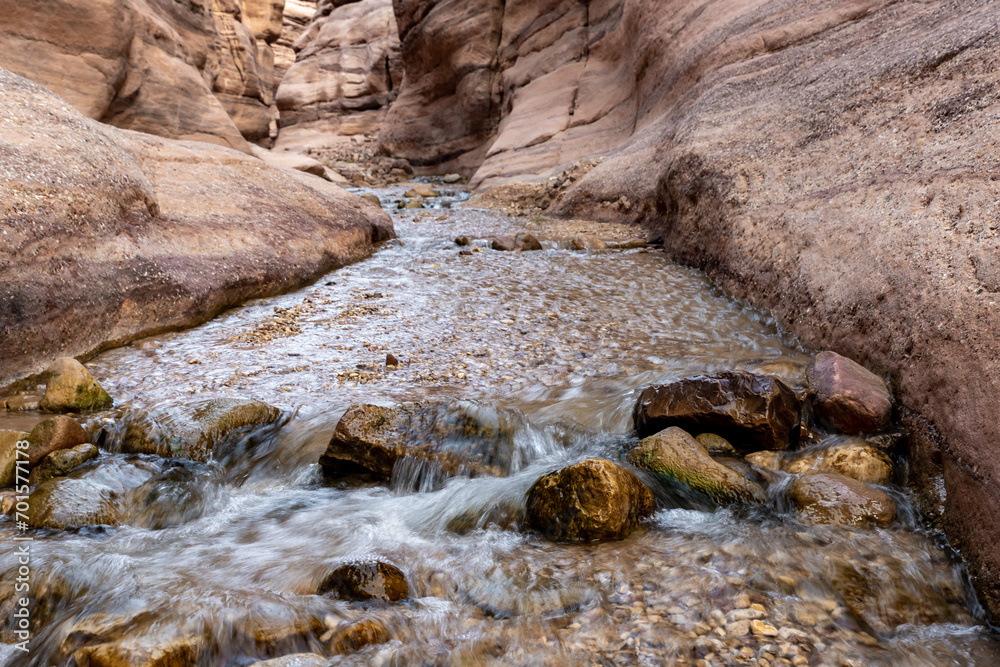 Fototapeta premium A small rapids along a shallow stream at the start of the Wadi Numeirah hiking trail in Jordan