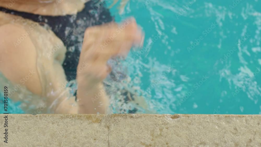Ovehead close-up of hands reaching out to touch the wall, signaling the imminent arrival of the swimmer with anticipation Ovehead close-up of hands reaching out to touch the wall, signaling the imminent arrival of the swimmer with anticipation