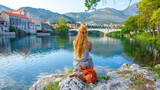 Woman tourist in Trebinje looking at river and bridge- Bosnia and Herzegovina