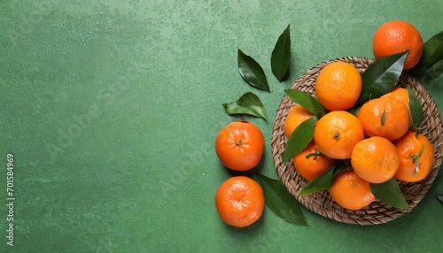 Many fresh ripe tangerines and leaves on light green table, flat lay. Space for text © Hamad Baloch