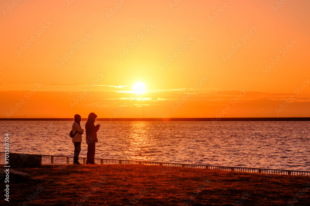 海から昇る日出と二人。神戸六甲アイランドのマリンパークで撮影