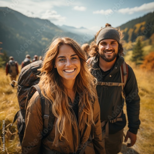 Young adults hiking mountain smiling with backpacks 