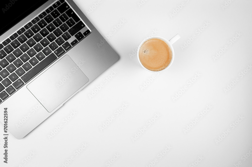 Top view of grey laptop computer on white background. Coffee cup, flat lay, copy space. Top view of grey laptop computer on white background. Coffee cup, flat lay, copy space.