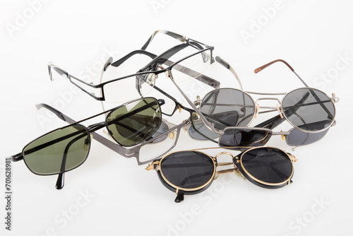 Set of glasses pairs of differently shaped sunglasses on gray table isolated on white background