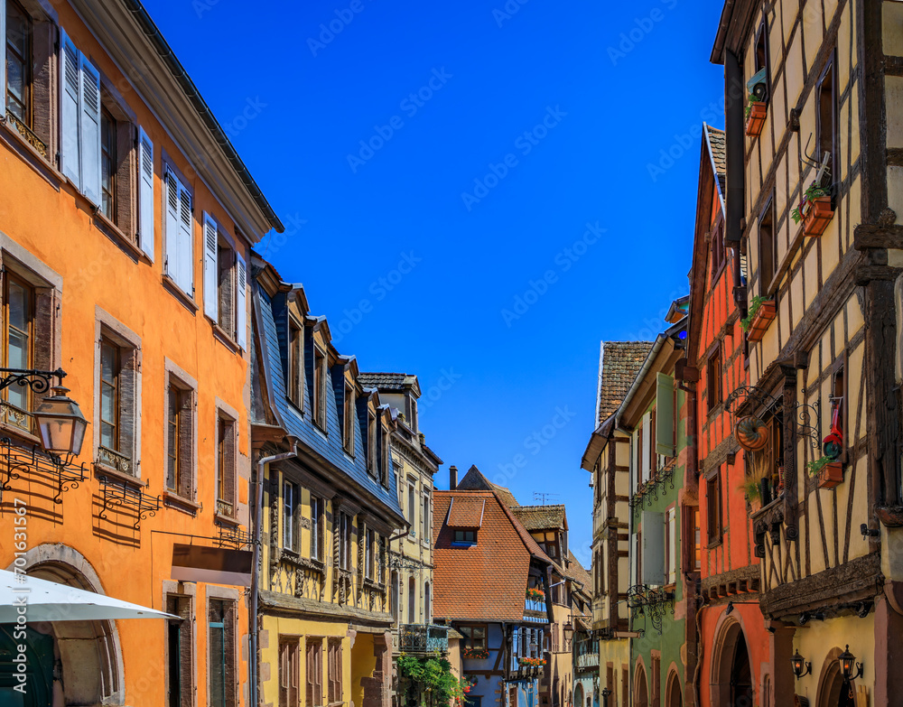 Ornate traditional half timbered houses with blooming flowers in a popular village on the Alsatian Wine Route in Riquewihr, France