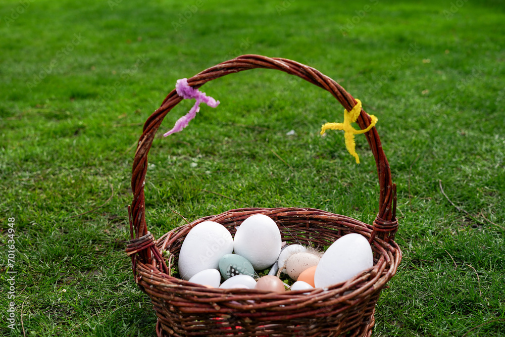Basket of Easter eggs on green grass, Happy Easter greeting card Basket of Easter eggs on green grass, Happy Easter greeting card