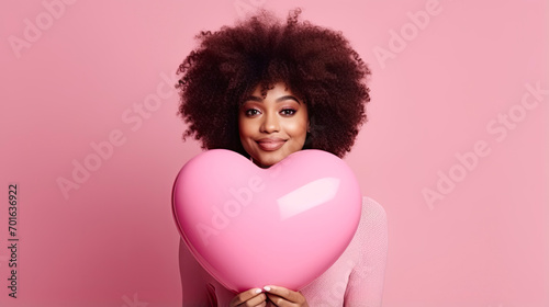 African American woman with heart shape air balloon on a pink valentine background