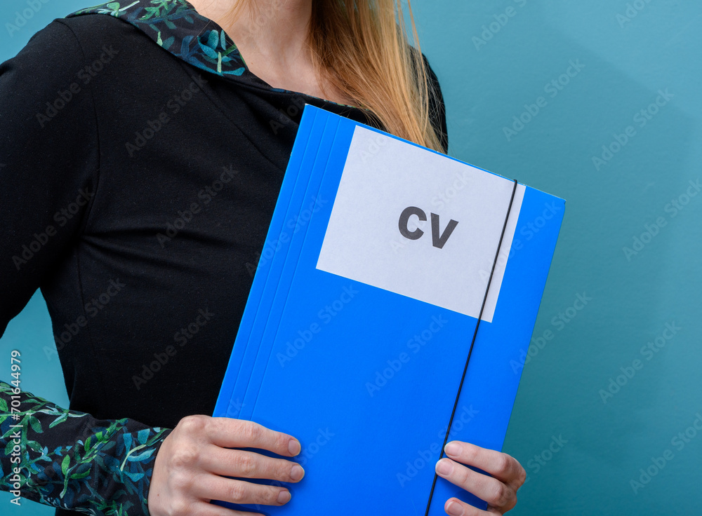 Dziewczyna trzyma w rękach teczkę z napisem CV, rozmowa kwalifikacyjna - obrazy, fototapety, plakaty 