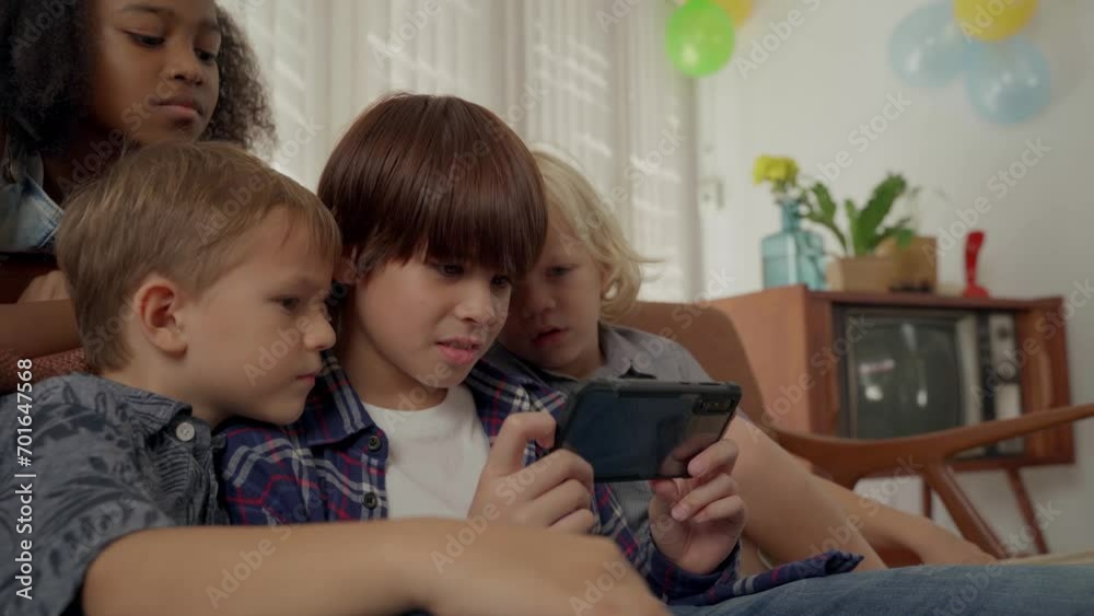 Boys sitting on sofa playing mobile game on smartphone Boys sitting on sofa playing mobile game on smartphone