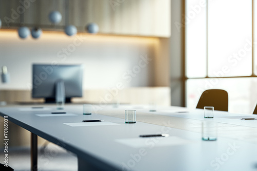 Close up of white table with items in modern conference room. Blurry interior background. Workplace concept. 3D Rendering.