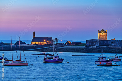 France, Brittany, Camaret-sur-Mer, Fishing boats anchored in front of village at dusk photo