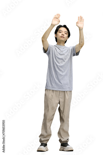 A guy in a gray T-shirt, on a white background, in full height, raised his hands up