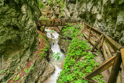 Austria, Tyrol,Hikers standing on bridge in Wolfsklamm canyon photo