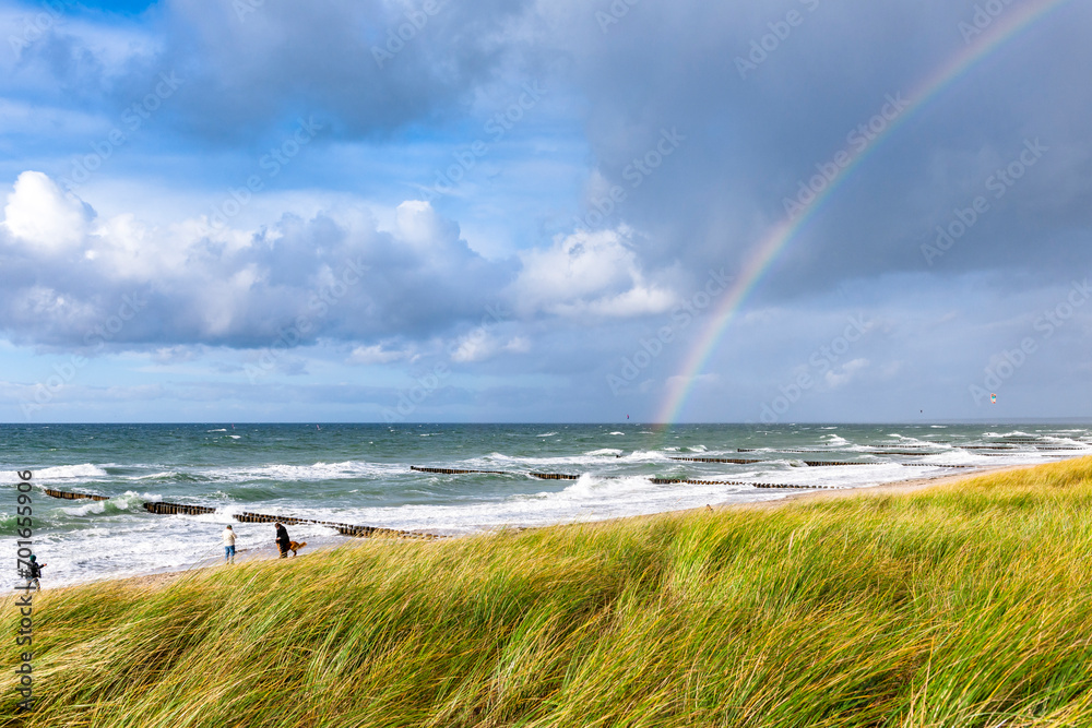 Germany, Mecklenburg-Vorpommern, Grassy beach with rainbow arching against cloudy sky over sea in background Germany, Mecklenburg-Vorpommern, Grassy beach with rainbow arching against cloudy sky over sea in background