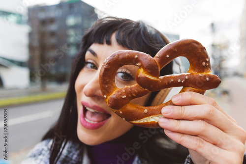 Woman with mouth open showing pretzel photo