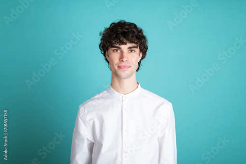 Confident young man against cyan background