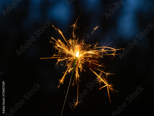Fototapeta Naklejka Na Ścianę i Meble -  Sparklers light up the night with their magical dance. These luminous wands trace ephemeral arcs, leaving trails of golden stardust in their wake.