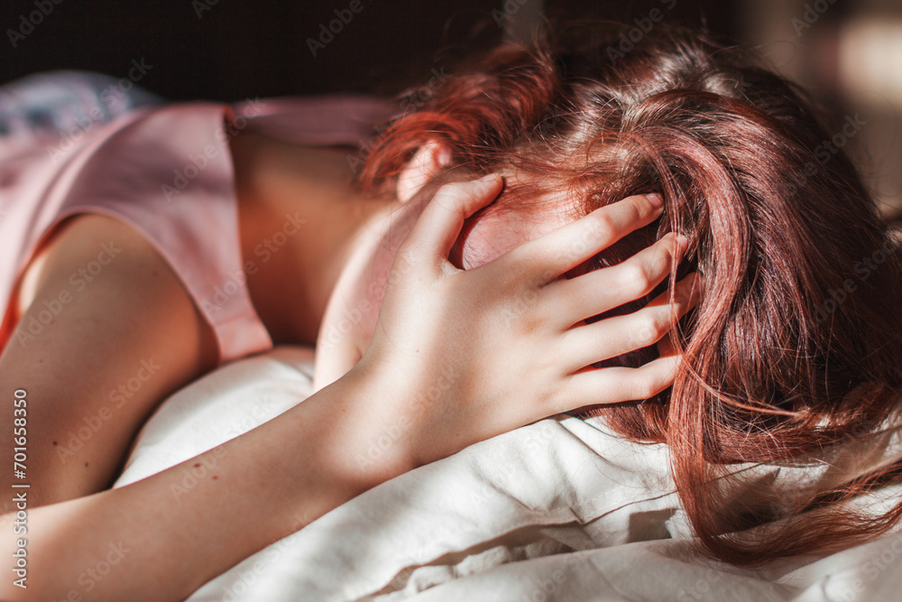 Sad young woman lying in bed Sad young woman lying in bed